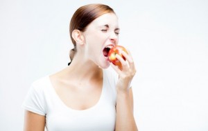 Woman holding and biting red apple, Healthy teeth